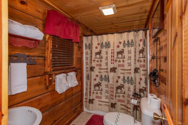 Bathroom with a tub and shower at Moonshiner's Ridge, a 1-bedroom cabin rental located in Pigeon Forge