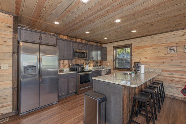 Kitchen with stainless steel appliances and breakfast bar at Heaven's Hill, a 3 bedroom cabin rental located in Gatlinburg
