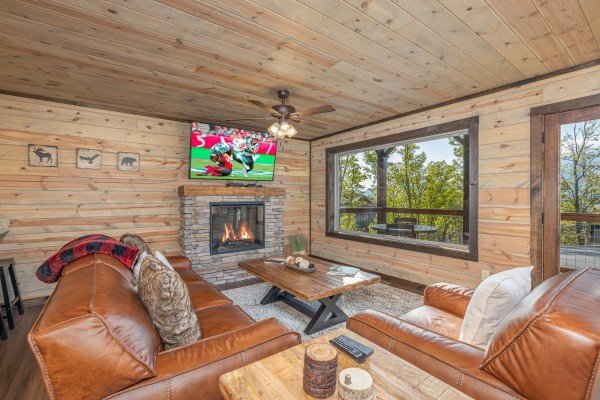 Fireplace, TV, and seating in the living room at Heaven's Hill, a 3 bedroom cabin rental located in Gatlinburg