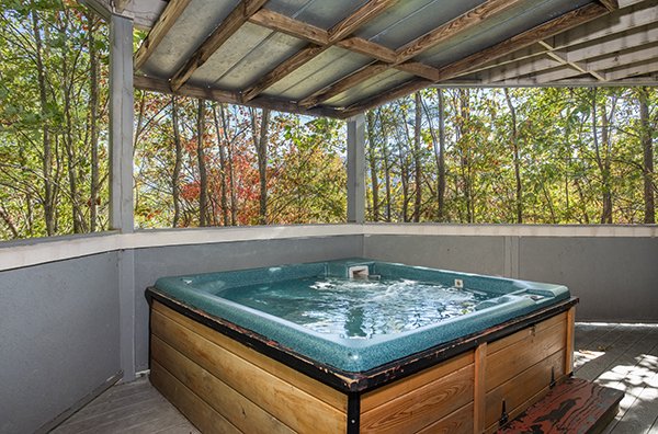 Hot tub on a covered deck at The Majestic, an 8 bedroom cabin rental located in Gatlinburg