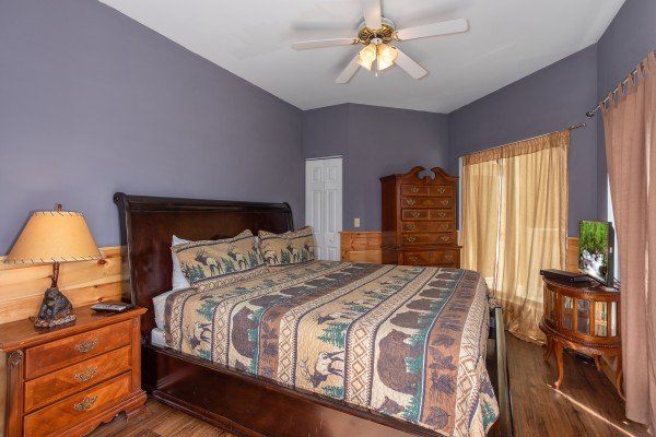 Bedroom with a king bed, dresser, and end tables at The Majestic, an 8 bedroom cabin rental located in Gatlinburg