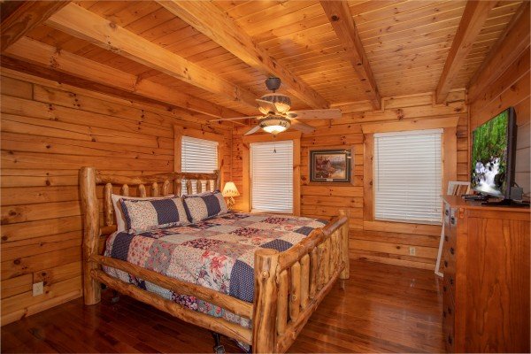 Bedroom with a king bed, dresser, and TV at The Cowboy Way, a 4 bedroom cabin rental located in Pigeon Forge