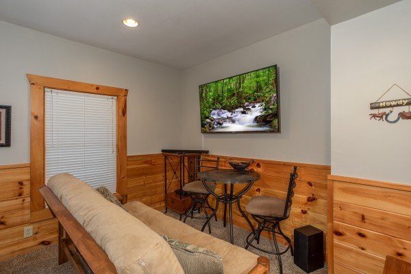 Bar table and TV in the game room at The Cowboy Way, a 4 bedroom cabin rental located in Pigeon Forge