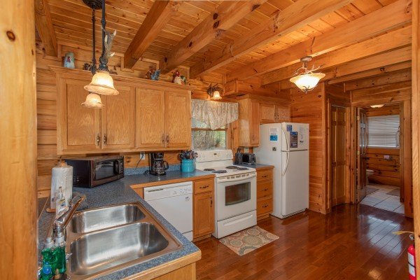 Kitchen with white appliances at The Cowboy Way, a 4 bedroom cabin rental located in Pigeon Forge