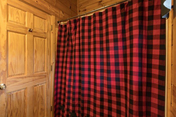 Bathroom with a tub and shower at Hibernation Station, a 3-bedroom cabin rental located in Pigeon Forge