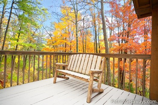 Log framed bench seat surrounded by fall foliage at Hooked on Bears, a 2 bedroom cabin rental located in Pigeon Forge