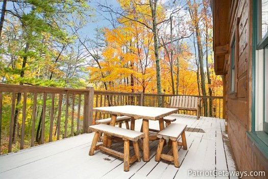Log framed patio table on the deck at Hooked on Bears, a 2 bedroom cabin rental located in Pigeon Forge