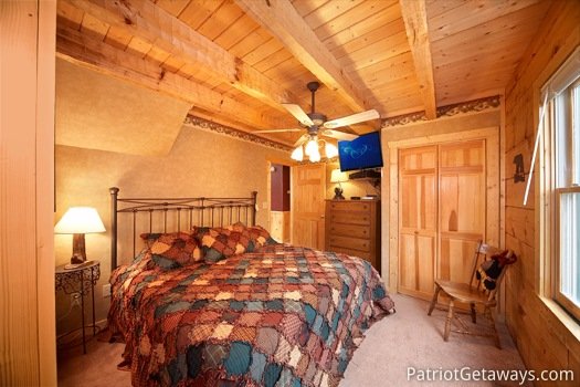 Main level bedroom with king sized bed and flat screen TV at Hooked on Bears, a 2 bedroom cabin rental located in Pigeon Forge
