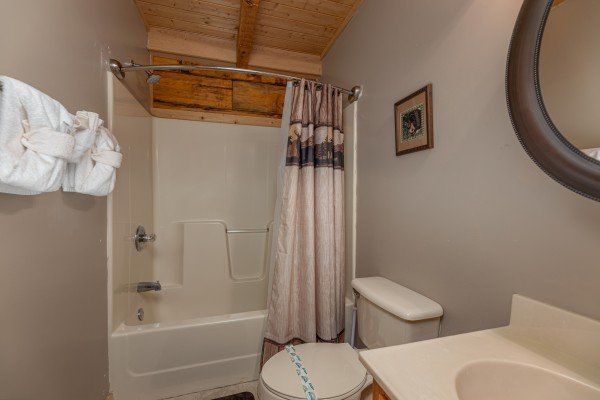 Bathroom with a tub and shower at Mickey's Playhouse, a 2 bedroom cabin rental located in Pigeon Forge
