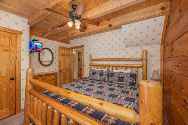 Bedroom with a log bed, dresser, and TV at Mickey's Playhouse, a 2 bedroom cabin rental located in Pigeon Forge