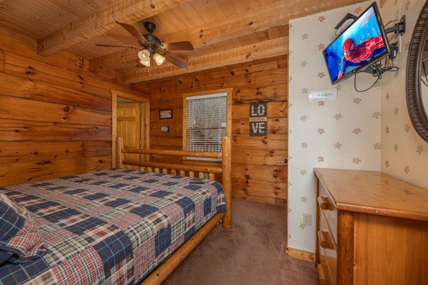 Bed, dresser, and TV in a bedroom at Mickey's Playhouse, a 2 bedroom cabin rental located in Pigeon Forge