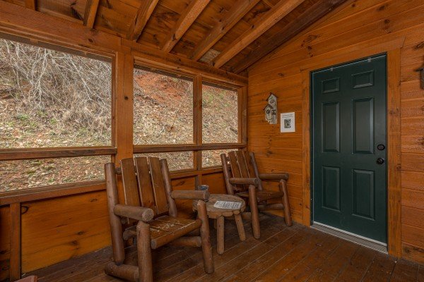 Two chairs on the screened in porch at Mickey's Playhouse, a 2 bedroom cabin rental located in Pigeon Forge