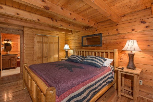 Bedroom with a king log bed, night stands, and lamps at Bear Mountain, a 2 bedroom cabin rental located in Pigeon Forge