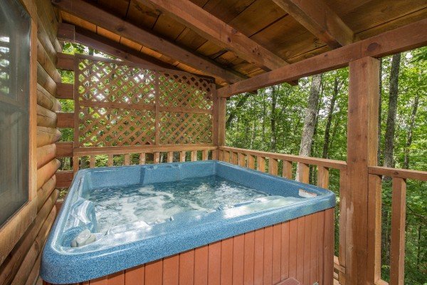 Hot tub on a covered deck at Bear Mountain, a 2 bedroom cabin rental located in Pigeon Forge