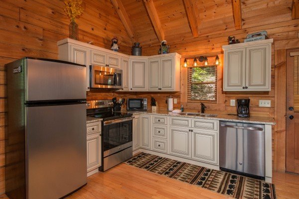 Kitchen with white cabinets and stainless appliances at Bear Mountain, a 2 bedroom cabin rental located in Pigeon Forge