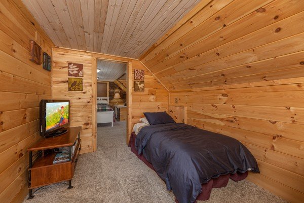 Twin bed and tv at A Mountain Hyde-a Way, a 2 bedroom cabin rental located in Pigeon Forge