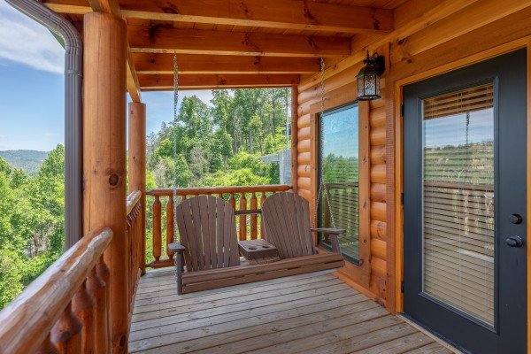 Adirondack Swing on a covered porch at Elk Horn Lodge, a 5 bedroom cabin rental located in Gatlinburg