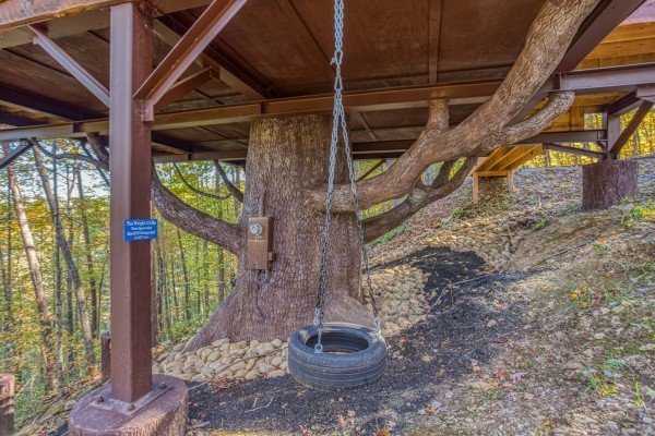 Tire swing mounted under the cabin at Smoky Mountain Treehouse, a 1 bedroom cabin rental located in Gatlinburg