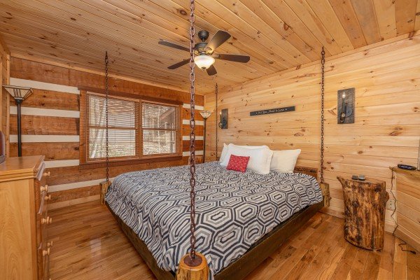 Hanging bed and log night table at Wild at Heart, a 1 bedroom cabin rental located in Gatlinburg