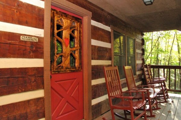 Front entry and rocking chairs on a covered porch at Wild at Heart, a 1 bedroom cabin rental located in Gatlinburg