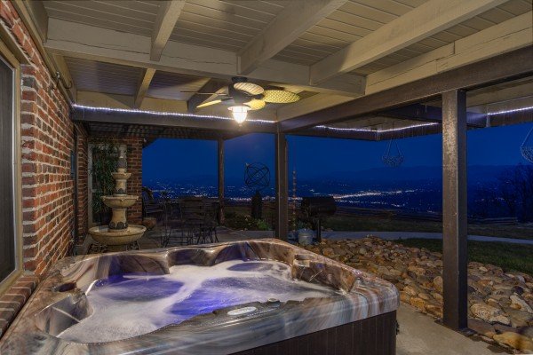 Hot tub on the patio with city lights in the background at Best View Ever! A 5 bedroom cabin rental located in Pigeon Forge