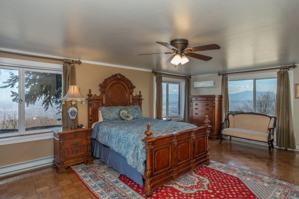 Bedroom with a bed, nightstand, chest of drawers, and sitting area at Best View Ever! A 5 bedroom cabin rental in Pigeon Forge