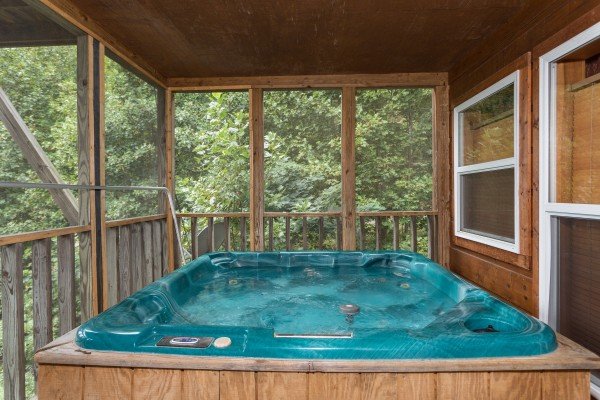 Hot tub on a screened in porch at Paradise View, a 1 bedroom cabin rental located in Pigeon Forge