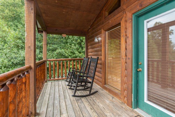 Rocking chairs on a covered deck at Paradise View, a 1 bedroom cabin rental located in Pigeon Forge