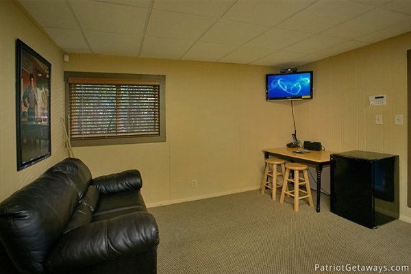 Seating and entertainment area of game room at Gatlinburg Lodge, a 6-bedroom cabin rental located in Gatlinburg