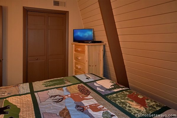 Third floor bedroom with TV and a dresser at Gatlinburg Lodge, a 6-bedroom cabin rental located in Gatlinburg