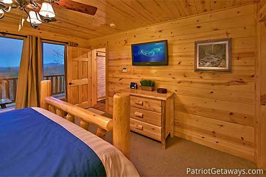 Flat screen tv mounted to wall at foot of bed at Gone to Therapy, a 2-bedroom cabin rental located in Gatlinburg