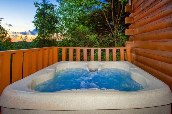 Hot tub on a deck with the sunset at Sweet Serenity, a 2 bedroom cabin rental located in Gatlinburg