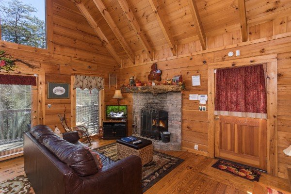 Living room with fireplace, tv, and deck access at Cloud 9, a 1-bedroom cabin rental located in Pigeon Forge