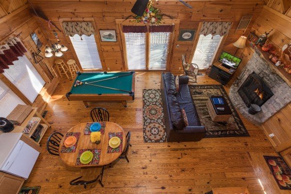 Living room, dining space, and pool table from the loft at Cloud 9, a 1-bedroom cabin rental located in Pigeon Forge