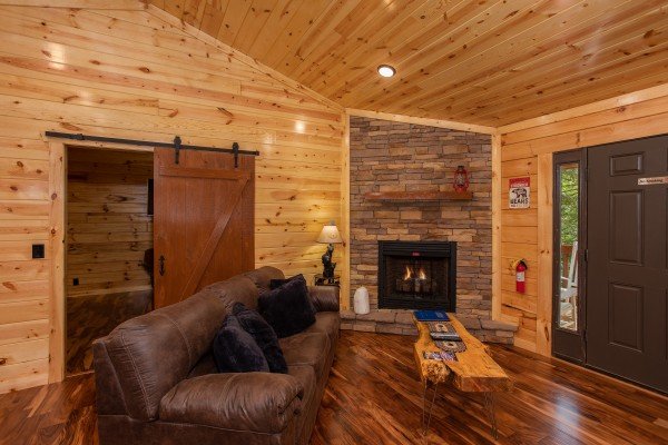 Fireplace and sliding barn door in the living room at Paws on the Porch, a 2 bedroom cabin rental located in Gatlinburg
