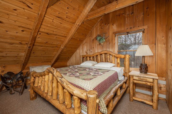 Log bed with night stand and lamp in the loft at Stellar View, a 1 bedroom cabin rental located in Pigeon Forge