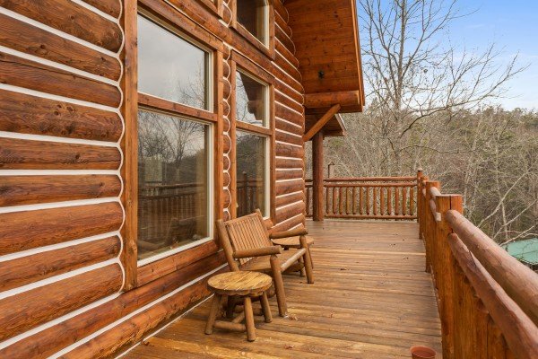 Bench and table on the deck at Rising Wolf Lodge, a 3 bedroom cabin rental located in Pigeon Forge