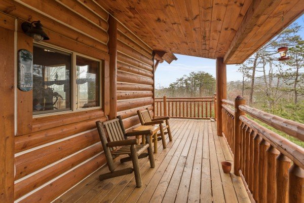 Chairs on a covered deck at Rising Wolf Lodge, a 3 bedroom cabin rental located in Pigeon Forge