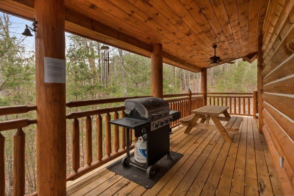 Grill and picnic table on a covered deck at Rising Wolf Lodge, a 3 bedroom cabin rental located in Pigeon Forge