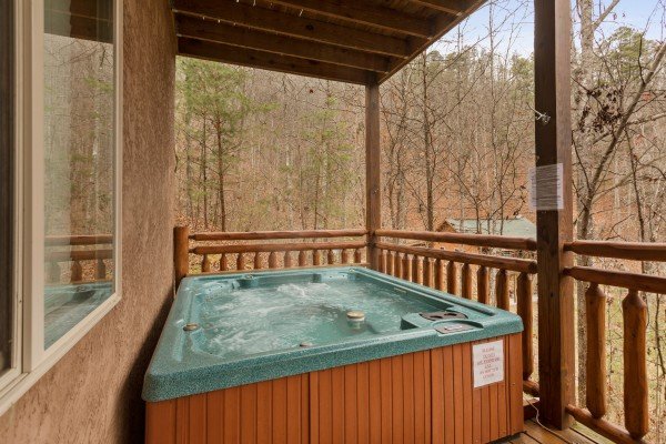 Hot tub on a covered deck at Rising Wolf Lodge, a 3 bedroom cabin rental located in Pigeon Forge