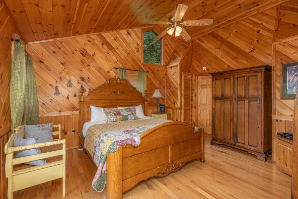 Bedroom with a king bed, bench, and armoire at Kaleidoscope, a 2 bedroom cabin rental located in Pigeon Forge