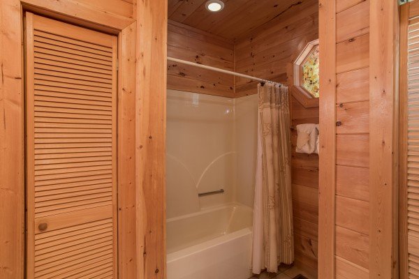 Bathtub and shower in a bathroom at Friends in High Places, a 4-bedroom cabin rental located in Pigeon Forge