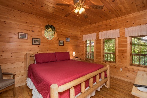 Bedroom with a log bed, night stand, and lamp at Friends in High Places, a 4-bedroom cabin rental located in Pigeon Forge