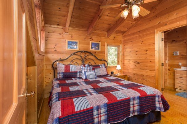 Bedroom with a bed, night stand, and en suite bathroom at Friends in High Places, a 4-bedroom cabin rental located in Pigeon Forge