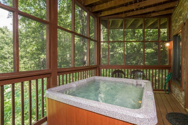 Hot tub on a screened porch at Friends in High Places, a 4-bedroom cabin rental located in Pigeon Forge