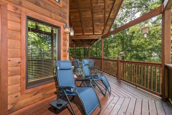 Lounge chairs on a covered deck at Friends in High Places, a 4-bedroom cabin rental located in Pigeon Forge