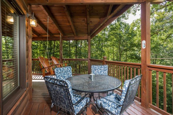 Dining table for four on the deck at Friends in High Places, a 4-bedroom cabin rental located in Pigeon Forge