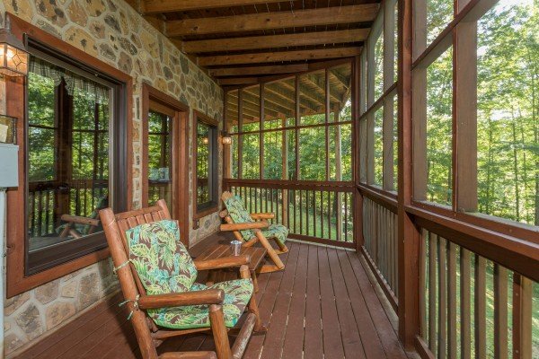 Screened in deck with rocking chairs at Friends in High Places, a 4-bedroom cabin rental located in Pigeon Forge