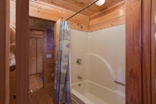 Bathtub and shower at Friends in High Places, a 4-bedroom cabin rental located in Pigeon Forge