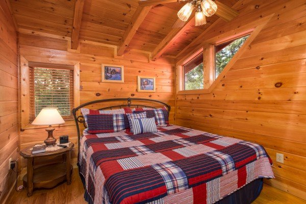 Bedroom with a bed, night stand, and lamp at Friends in High Places, a 4-bedroom cabin rental located in Pigeon Forge